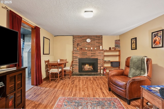 2235 SE 185th Ave, Portland, OR 97233 - living room featuring light wood-type flooring, a textured ceiling, and a fireplace