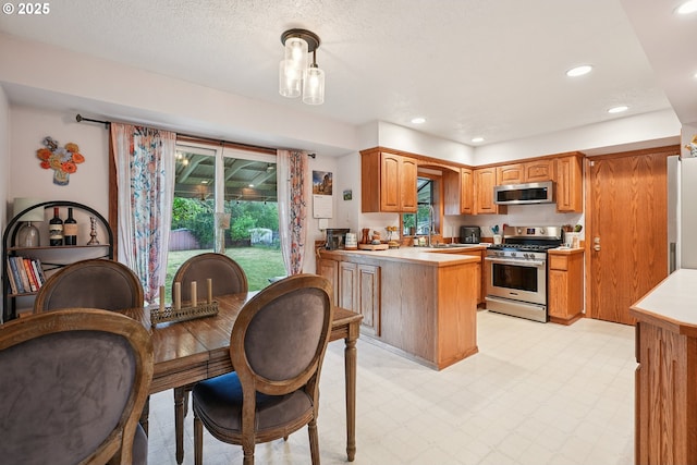 2235 SE 185th Ave, Portland, OR 97233 - kitchen featuring stainless steel appliances, a peninsula, light countertops, light flooring, and recessed lighting