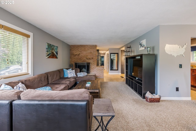 carpeted living room featuring a brick fireplace and baseboards