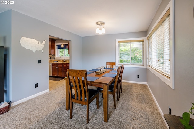 dining room with healthy amount of natural light, light colored carpet, and baseboards