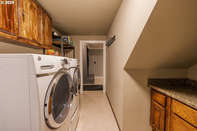 laundry room featuring washer and dryer, cabinet space, and light tile patterned floors