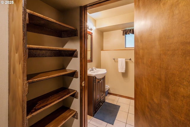 half bath featuring tile patterned floors and a sink