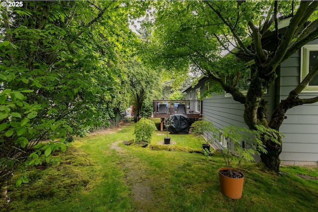 view of grassy yard with a deck