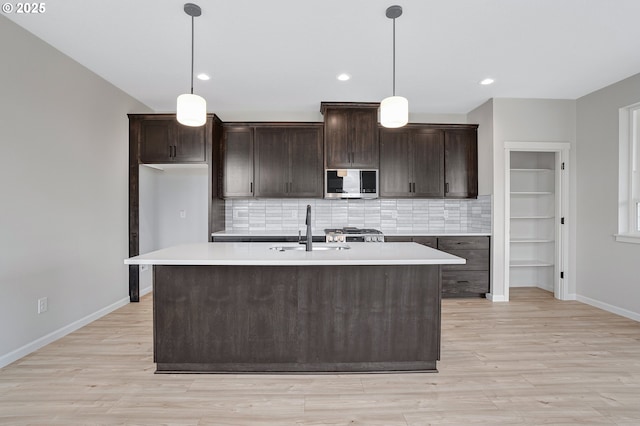 4636 SE 2nd St, Gresham, OR 97080 - kitchen with stainless steel microwave, dark brown cabinetry, tasteful backsplash, light countertops, and recessed lighting