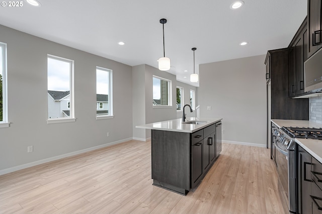 4636 SE 2nd St, Gresham, OR 97080 - kitchen with stainless steel appliances, light countertops, a kitchen island with sink, light wood-style floors, and recessed lighting