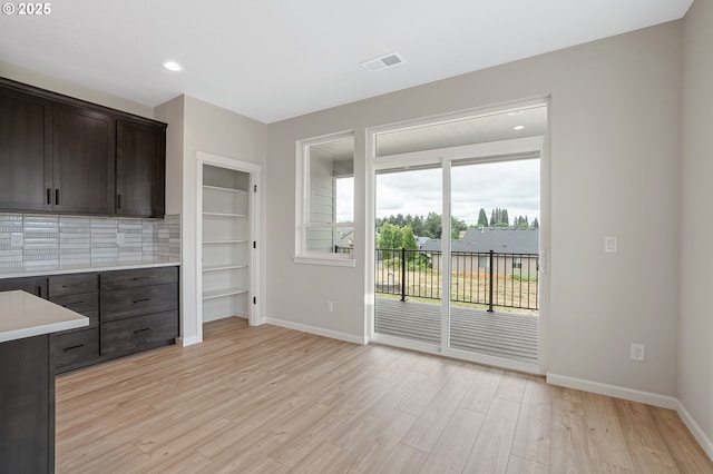 4636 SE 2nd St, Gresham, OR 97080 - kitchen featuring light countertops, light wood-style floors, dark brown cabinets, decorative backsplash, and recessed lighting