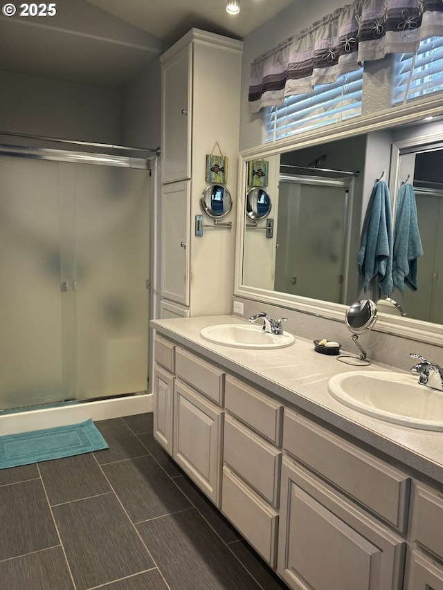 bathroom with a sink, double vanity, and a stall shower