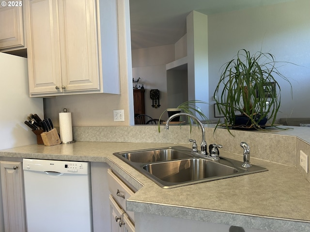 kitchen with a sink, light countertops, white dishwasher, and white cabinets