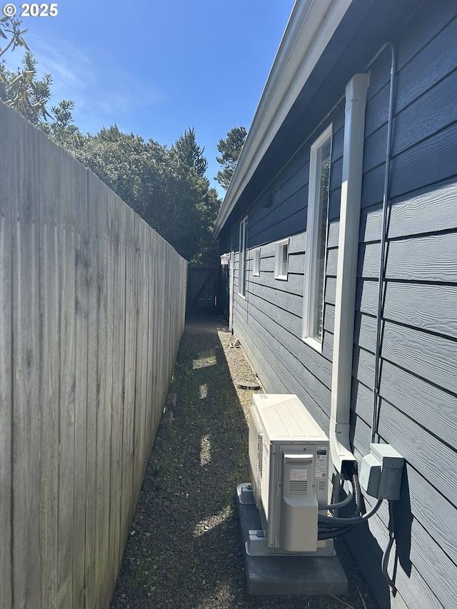 view of side of home with fence and ac unit