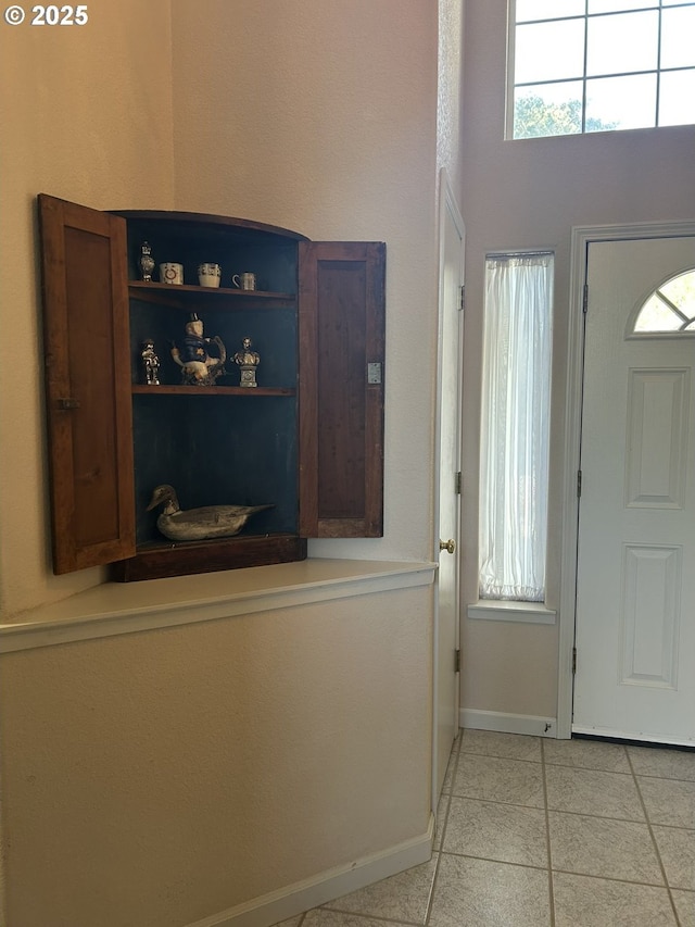 entrance foyer with light tile patterned floors and baseboards