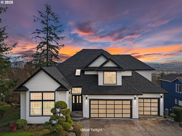 view of front facade featuring a shingled roof, driveway, and a garage