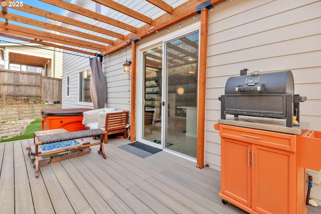 wooden terrace featuring a pergola, fence, a grill, and a hot tub