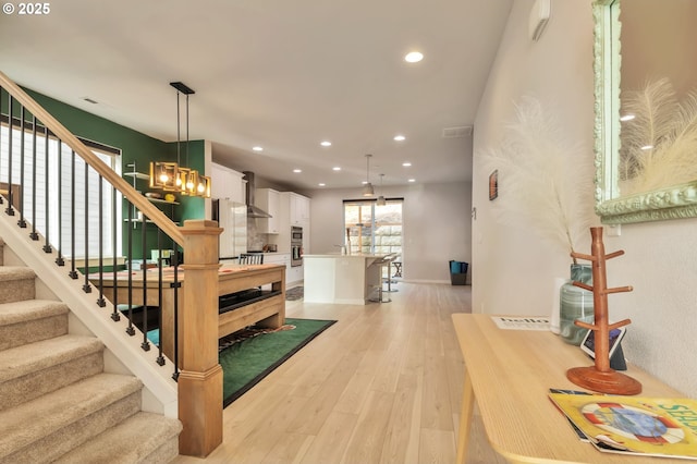 stairs with baseboards, wood finished floors, visible vents, and recessed lighting