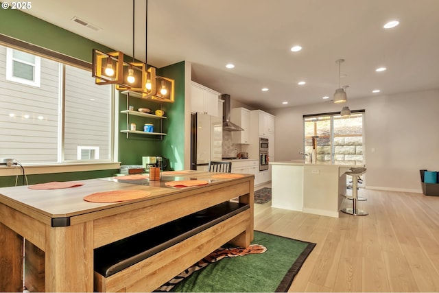 dining area featuring baseboards, light wood-type flooring, visible vents, and recessed lighting