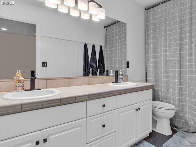 full bath with toilet and double vanity