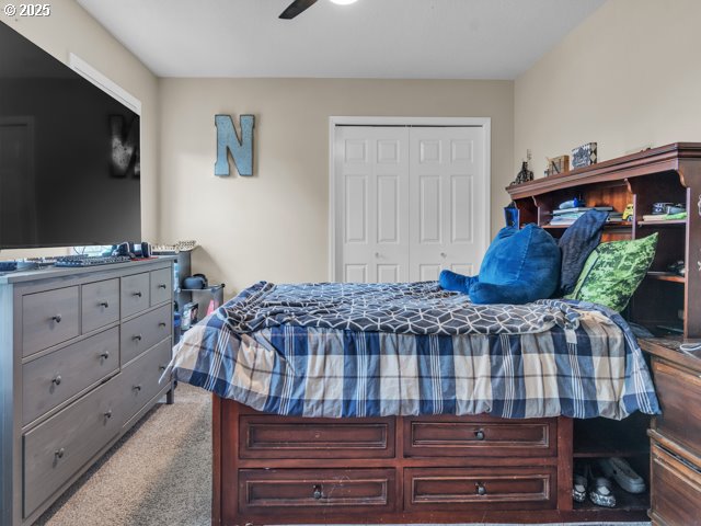 bedroom with a closet, carpet, and ceiling fan