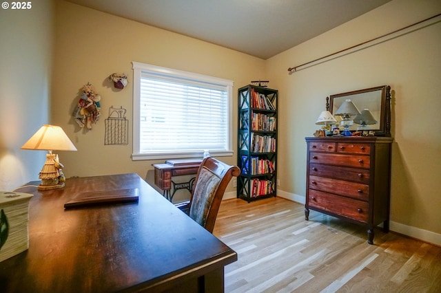 home office featuring light wood-type flooring and baseboards