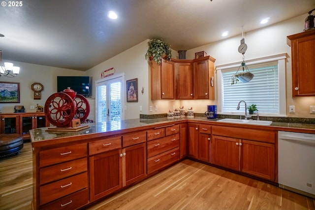 kitchen featuring a sink, white dishwasher, a peninsula, tile counters, and brown cabinets