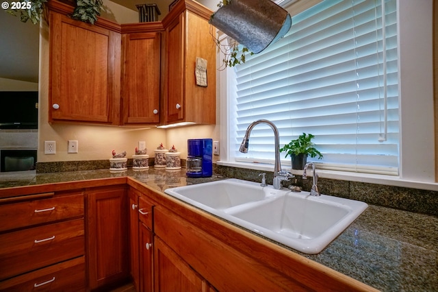 kitchen with a sink, brown cabinets, and tile countertops