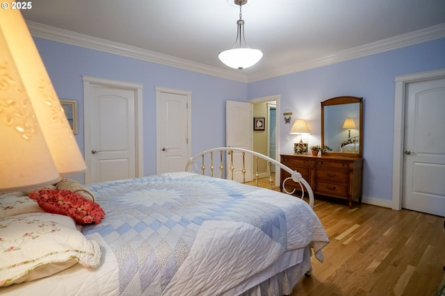 bedroom featuring crown molding, wood finished floors, and baseboards