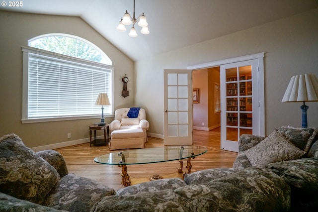 living area featuring french doors, vaulted ceiling, wood finished floors, a chandelier, and baseboards