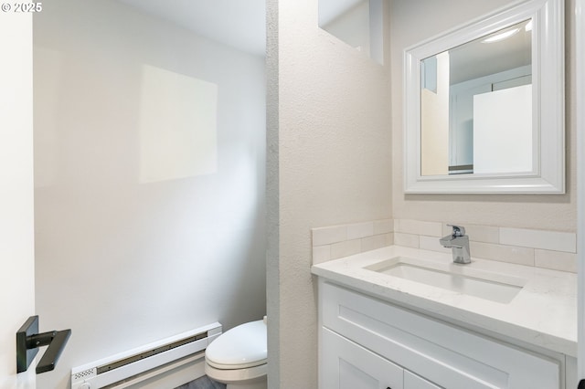 bathroom with baseboard heating, toilet, and vanity