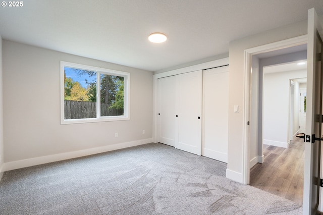 unfurnished bedroom with light carpet and a closet