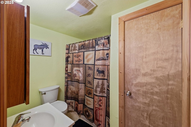 full bath with a sink, toilet, and a shower with curtain