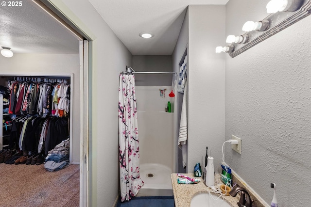 458 16th Ave, Coos Bay, OR 97420 - bathroom featuring a shower stall, a walk in closet, vanity, and a textured wall