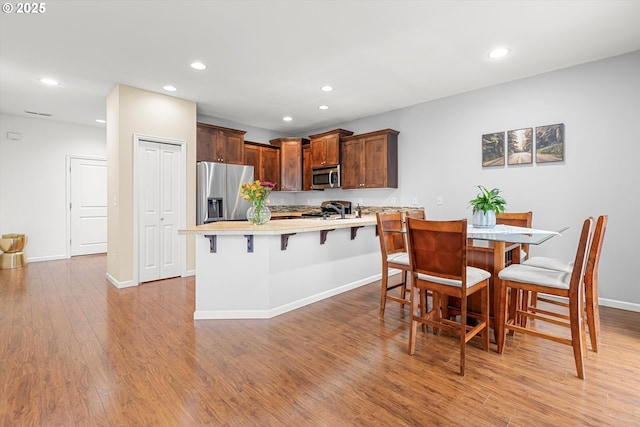 5503 NE 53rd Cir, Vancouver, WA 98661 - kitchen featuring stainless steel appliances, light countertops, recessed lighting, light wood-style flooring, and a breakfast bar area