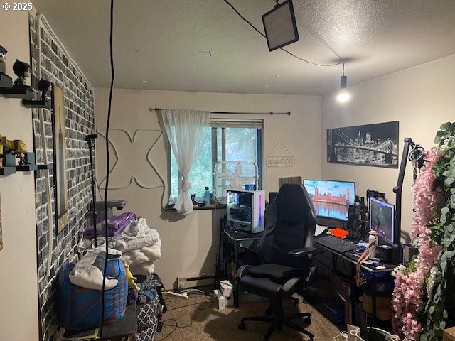 office featuring a baseboard heating unit, carpet flooring, and a textured ceiling