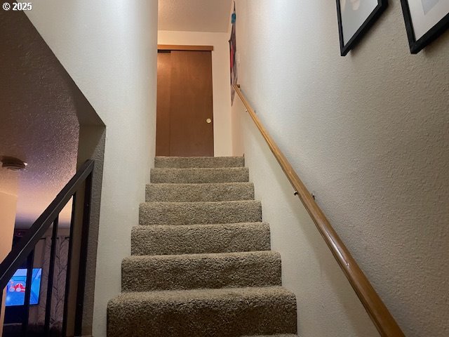 staircase featuring a textured wall