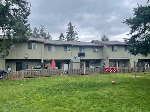 back of house featuring a lawn and fence