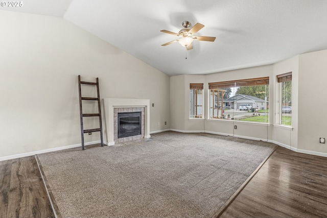 unfurnished living room featuring a tile fireplace, ceiling fan, dark hardwood / wood-style flooring, and lofted ceiling