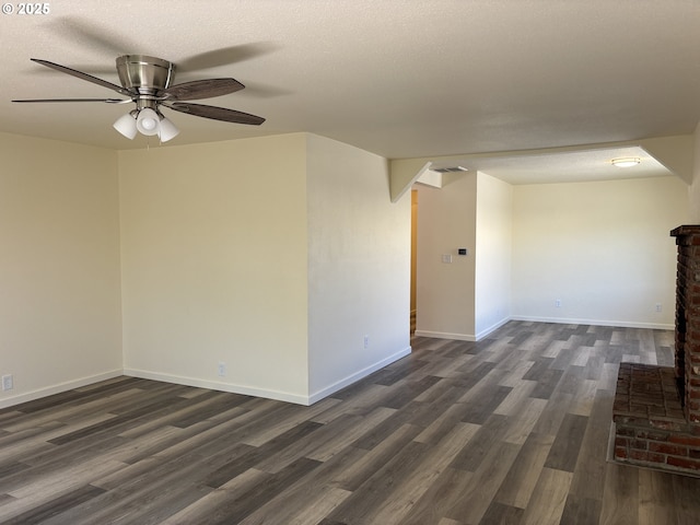 empty room with baseboards, ceiling fan, dark wood-style floors, and visible vents