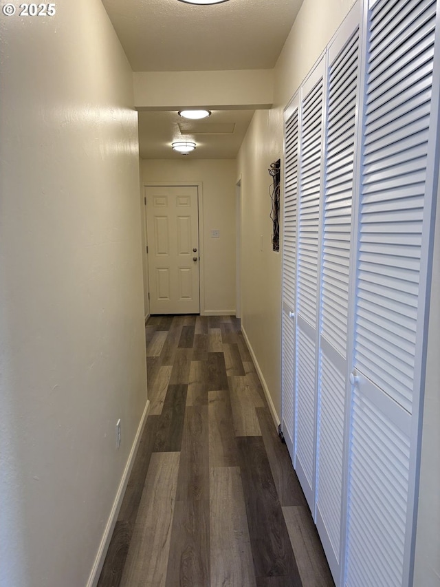 hall with baseboards and dark wood-style floors