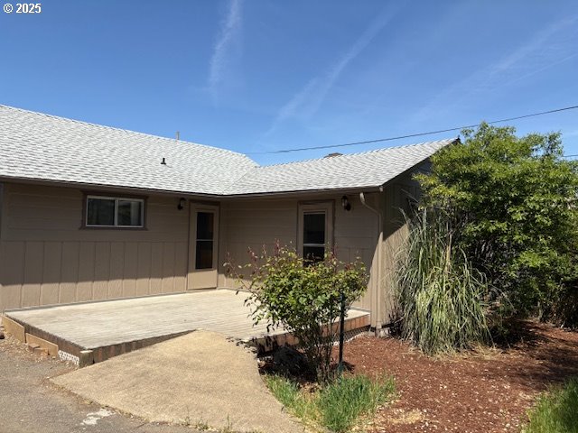 rear view of house featuring roof with shingles