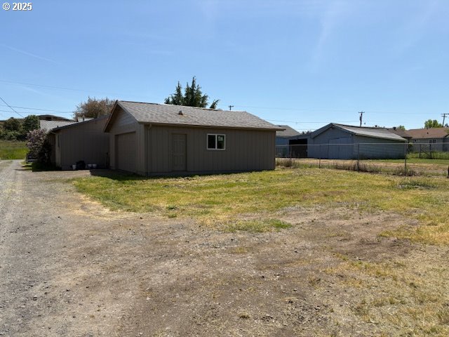 back of property featuring fence and a garage
