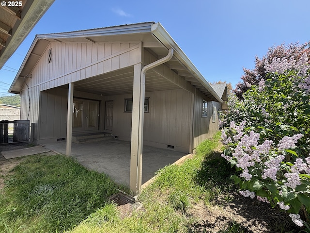 view of side of property with a patio and crawl space