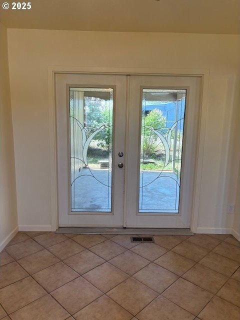 entryway with light tile patterned floors, baseboards, french doors, and visible vents