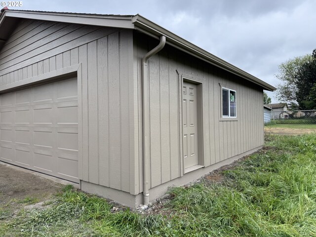 view of property exterior featuring fence and a garage