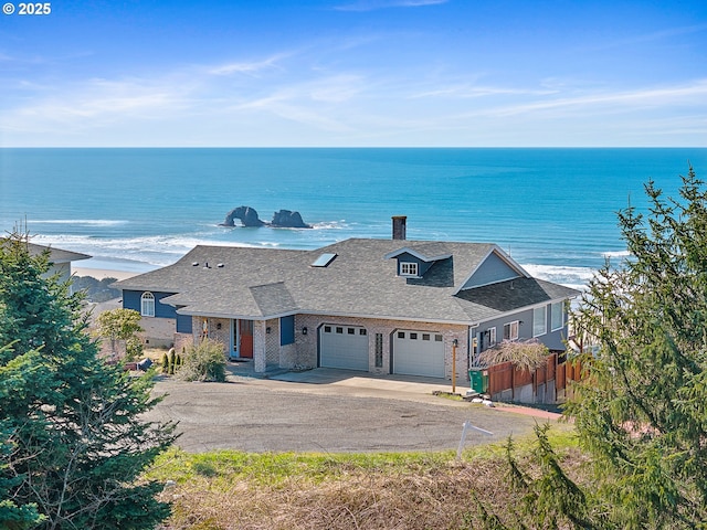 view of front of house featuring driveway, a shingled roof, an attached garage, fence, and brick siding