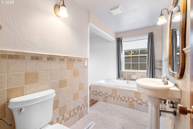 1897 Chelan St, Keizer, OR 97303 - bathroom featuring a bath, tile walls, toilet, and tile patterned floors