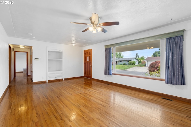 1897 Chelan St, Keizer, OR 97303 - spare room featuring built in shelves, baseboards, ceiling fan, and light wood-type flooring