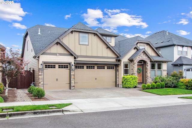 craftsman-style house with stone siding, fence, board and batten siding, and a shingled roof