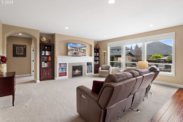 living area with a tiled fireplace, recessed lighting, and baseboards