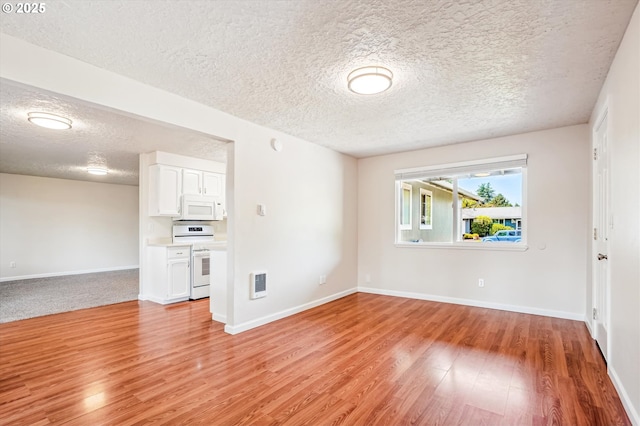 2380 NE Rene Ave, Gresham, OR 97030 - unfurnished living room with light wood-type flooring, a textured ceiling, and heating unit