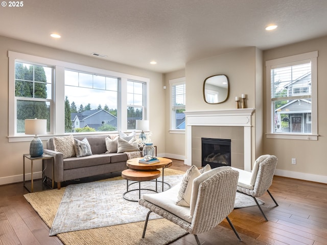 14420 SW Equestrian Ln, Beaverton, OR 97008 - living room featuring baseboards, healthy amount of natural light, a tile fireplace, hardwood / wood-style flooring, and recessed lighting