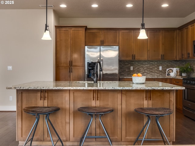 14420 SW Equestrian Ln, Beaverton, OR 97008 - kitchen with appliances with stainless steel finishes, tasteful backsplash, recessed lighting, wood finished floors, and a breakfast bar