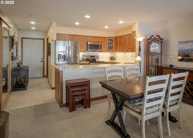 1 3rd St, Astoria, OR 97103 - kitchen with appliances with stainless steel finishes, glass insert cabinets, recessed lighting, light countertops, and a peninsula